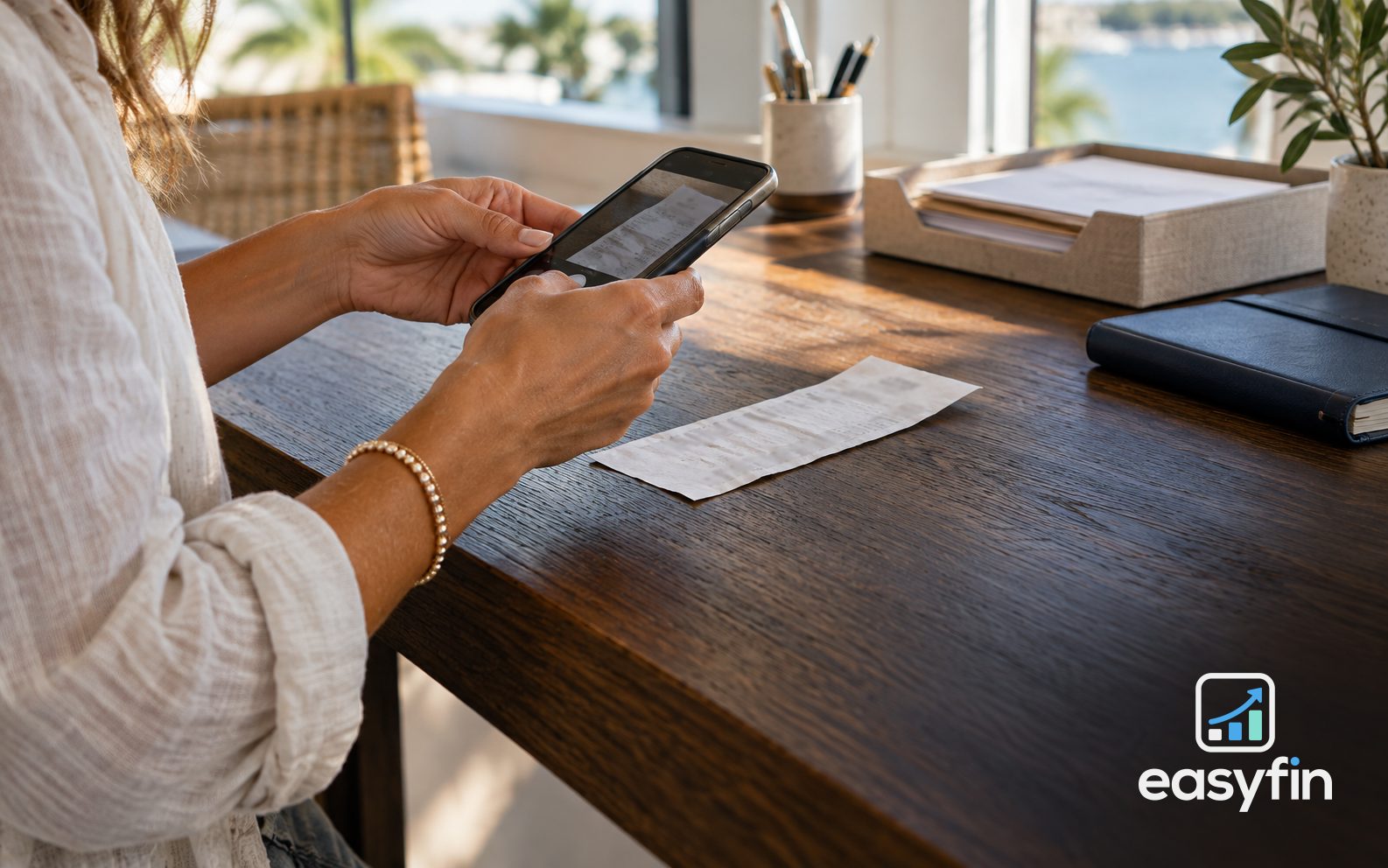 Business owner using a smartphone to photograph a receipt.